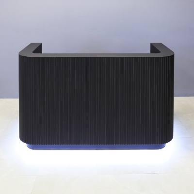 72-inch Nola Custom Reception Desk in black traceless tambour main desk, black traceless laminate workspace & toe-kick, and warm white LED.