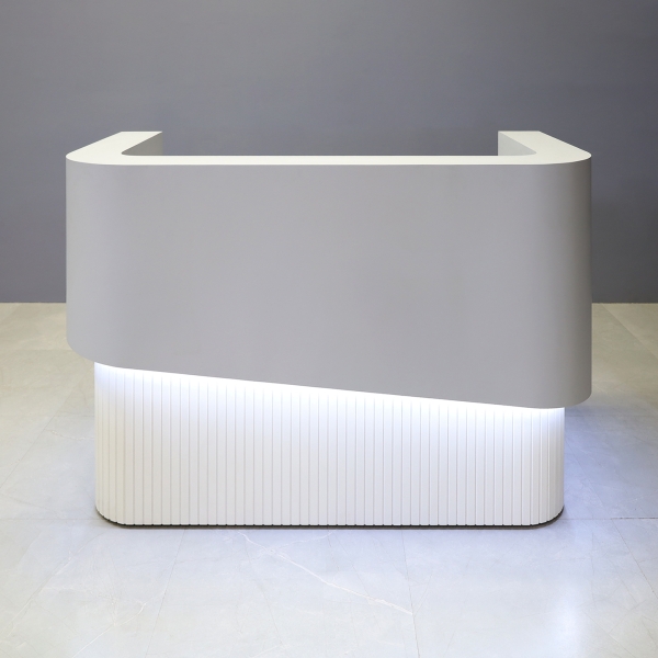60-inch Nola Curved Reception Desk in folkstone gray matte laminate counter & inside desk, white tambour outside desk, and warm white LED.