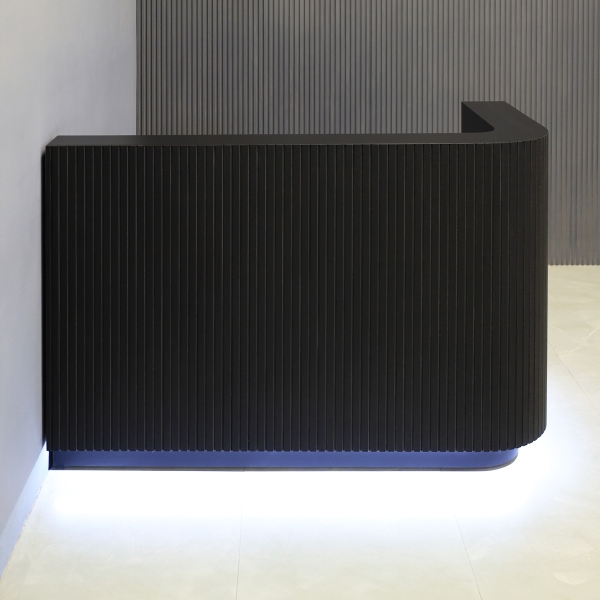60-inch Nola L-Shape Custom Reception Desk with the l-panel on the right side. The main desk is covered in black traceless tambour, the workspace and toe-kick in black matte laminate, and comes with warm white LED.