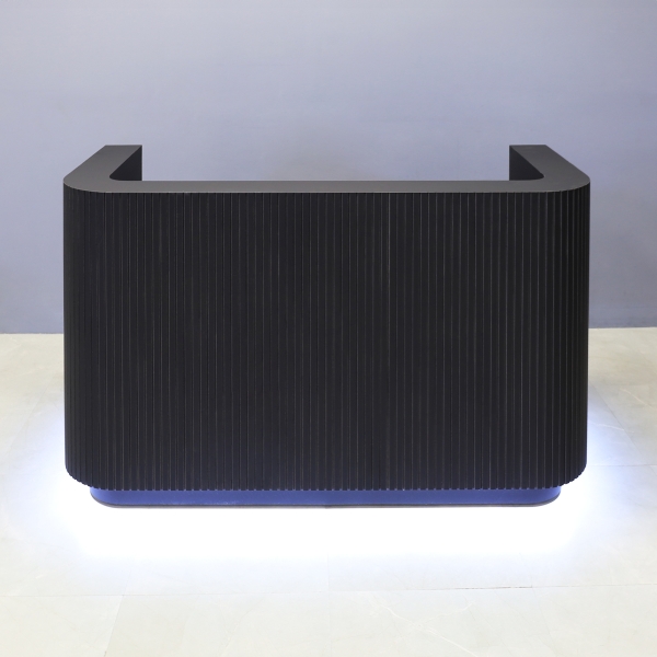 72-inch Nola Custom Reception Desk in black traceless tambour main desk, black traceless laminate workspace & toe-kick, and warm white LED.