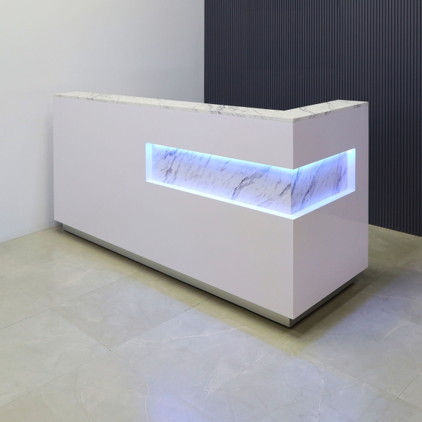 90-inch Manhattan L-Shape Custom Reception Desk in calcutta stone pvc laminate accent panel and top counter, and white matte laminate main desk. Brushed aluminum toe-kick, with multi-colored LED, shown here.