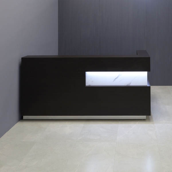 90-inch Manhattan L-Shape Custom Reception Desk in calcutta stone PVC accent pane, and ebony recon matte laminate main desk, with gold aluminum toe-kick, and warm white LED, shown here.