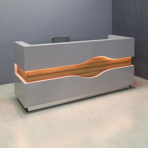 90-inch Wave Reception Desk in light gray gloss laminate desk and counter, zebrawood veneer wave accent front, and brushed aluminum toe-kick, with warm white LED, shown here.
